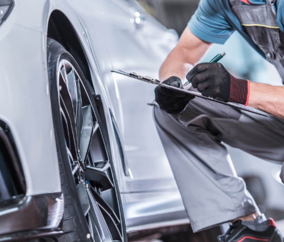 整備士が点検表を持ってタイヤ周りを確認している様子