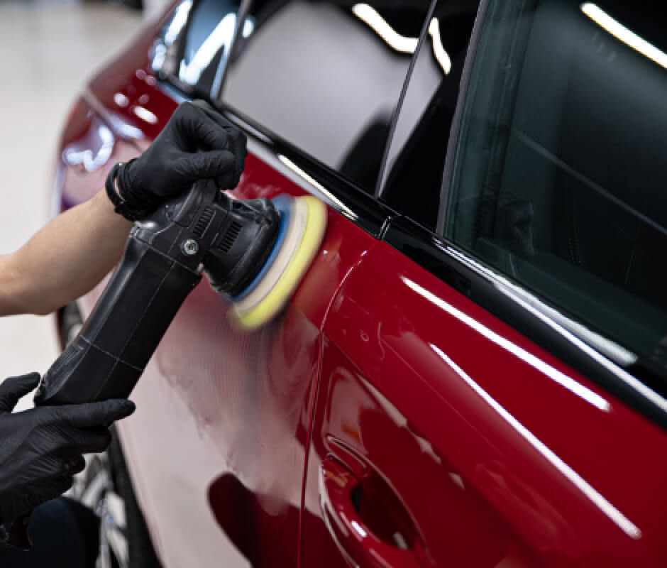 車のボディをポリッシャーで磨いている様子