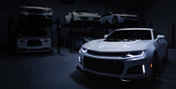 白いスポーツカーをはじめたくさんの車が保管されているガレージ