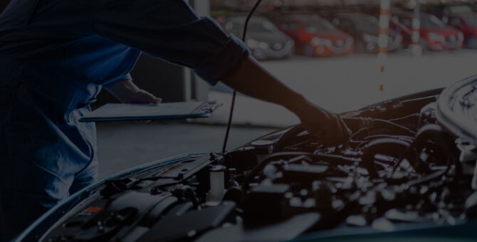 整備士がボンネットを開けてエンジンルームを点検している様子